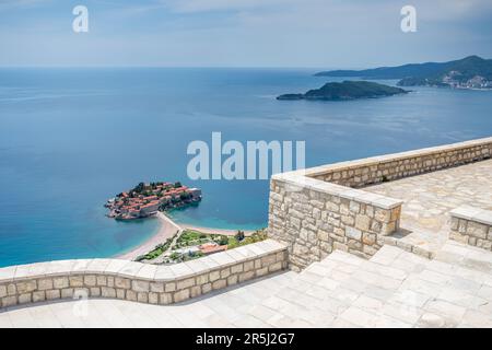 Si affaccia sull'esterno lastricato e murato della Chiesa di San Sava, sopra la montagna verso Sveti Stefan e la costa del Montenegro. Foto Stock