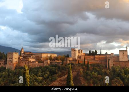 Vista completa dell'Alhambra, castello storico moresco, situato a Granada, Spagna, con il suggestivo cielo al tramonto Foto Stock