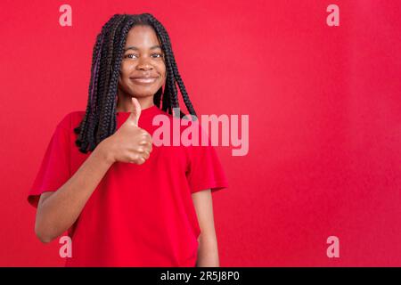 Felice donna africana gesturing accordo alzando un pollice in su Foto Stock