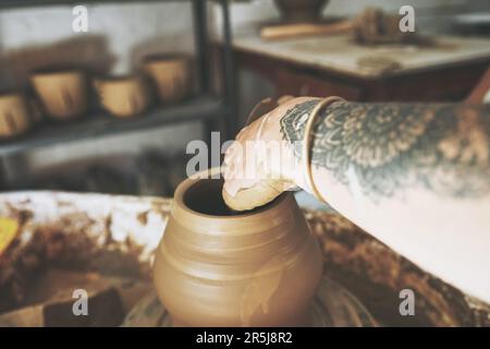 Sede delle migliori pentole del mondo. una donna irriconoscibile che lavora con l'argilla in uno studio di ceramica. Foto Stock