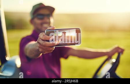 Gioco di golf da myselfie. un giovane uomo che prende un selfie su un campo da golf. Foto Stock