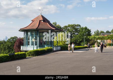 Persone che camminano accanto alla tribuna, Horniman Gardens, Forest Hill, Londra, SE23, Inghilterra, Regno Unito Foto Stock