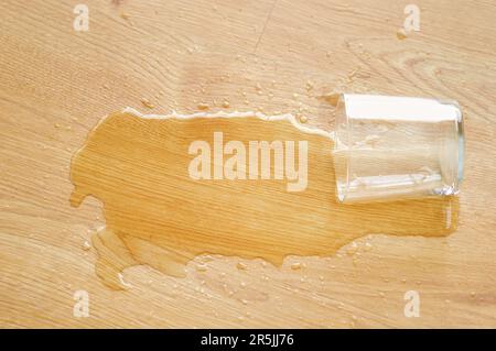 parquet in legno laminato con un bicchiere d'acqua sulla superficie Foto Stock