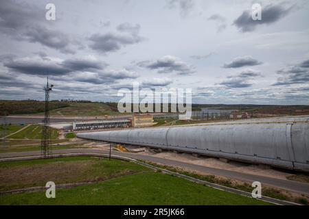 Sergiyev Posad, Russsia - 18 maggio 2022: Pipe e alberi della centrale idroelettrica Zagorskaya su sfondo grigio Foto Stock