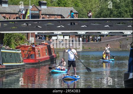 Brindley Place, Birmingham 4th giugno 2023 - i visitatori del centro di Birmingham hanno goduto di temperature che hanno raggiunto i 22 gradi Celsius mentre la mini ondata di caldo continua la domenica pomeriggio. La gente si è divertita con il paddleboard e le barche a motore per godersi i canali della città e ha usato sedie a sdraio per prendere il sole a Brindley Place. Molti amanti del sole sono stati avvistati in pub affollati sul canalside e rilassarsi su gradini. Credit: Stop Press Media/Alamy Live News Foto Stock