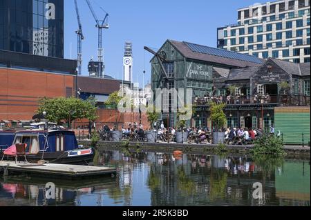 Brindley Place, Birmingham 4th giugno 2023 - i visitatori del centro di Birmingham hanno goduto di temperature che hanno raggiunto i 22 gradi Celsius mentre la mini ondata di caldo continua la domenica pomeriggio. La gente si è divertita con il paddleboard e le barche a motore per godersi i canali della città e ha usato sedie a sdraio per prendere il sole a Brindley Place. Molti amanti del sole sono stati avvistati in pub affollati sul canalside e rilassarsi su gradini. Credit: Stop Press Media/Alamy Live News Foto Stock