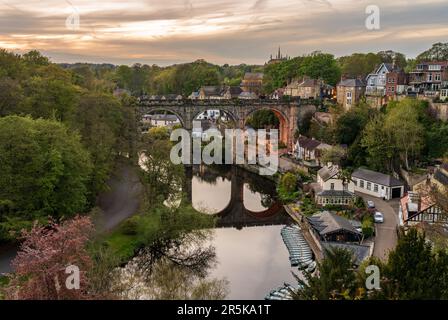 Viadotto di pietra sul fiume Nidd a Knaresborough con barche a remi in riva al fiume Foto Stock