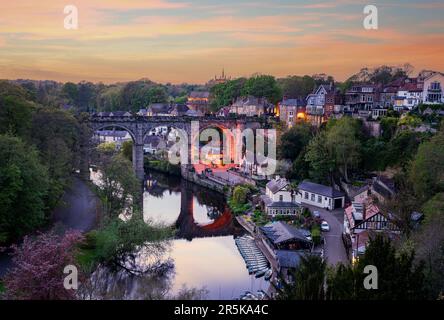 Viadotto di pietra sul fiume Nidd a Knaresborough con barche a remi in riva al fiume Foto Stock