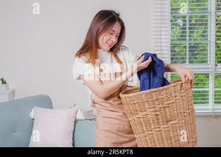 Giovane donna che pulisce nel soggiorno di casa Foto Stock