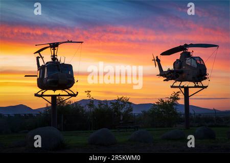 Ritirati UH-1 Iroquois ('Huey') e AH-1 Cobra Elicotters prima di vibranti colori alba presso l'aeroporto municipale di Susanville - Lassen County CA, USA. Foto Stock