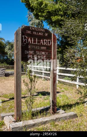 Un segno di legno intagliato, ai limiti del villaggio, per il villaggio di Ballard, California situato nella valle di Santa Ynez nella contea di Santa Barbara. Foto Stock