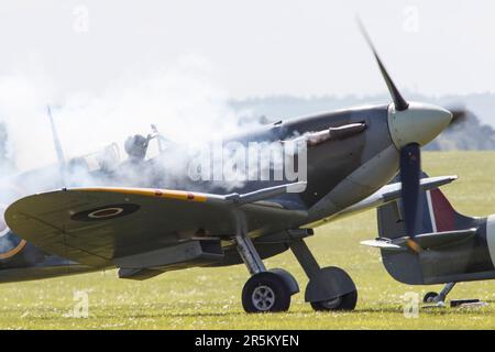 Un motore spitfire fuma all'avviamento alla RAF di Duxford per l'esibizione aerea nel maggio 2023 Foto Stock