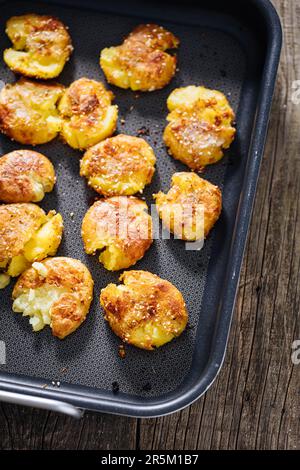 Patate al forno o arrosto in vassoio di metallo condito con rosmarino e sale e pepe. Dorato e croccante. Foto Stock