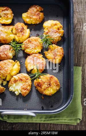 Patate al forno o arrosto in vassoio di metallo condito con rosmarino e sale e pepe. Dorato e croccante. Foto Stock