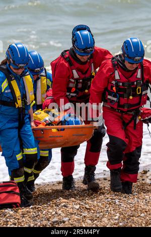 Visualizzazione congiunta dei servizi di emergenza con particolare attenzione alla sicurezza delle acque. Gli equipaggi e le navi di RNLI e della Guardia costiera dimostrano il recupero di una vittima dal mare. Foto Stock