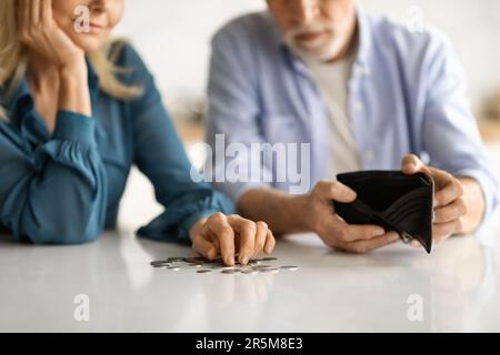 Concetto di povertà. Sposi anziani rovesciati Cointing monete sul tavolo in cucina Foto Stock