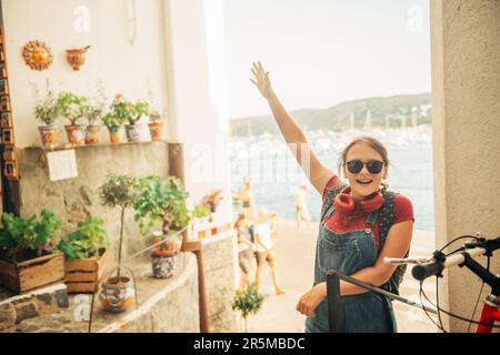 Divertente ragazza viaggiatore adolescente a piedi per le strade della Costa Brava, con zaino. Viaggio con bambini vacanza in famiglia nel sud della Spagna, immagine presa io Foto Stock