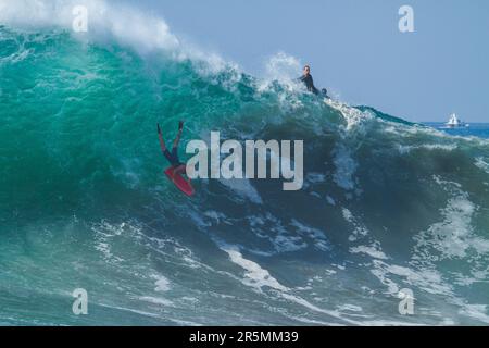Bodyboarder boogie boarding in discesa su una grande onda a Wedge Newport Beach, California, Stati Uniti Foto Stock