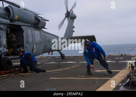 230423-N-EU502-3157 OCEANO PACIFICO (23 aprile 2023) - Seaman Jacob Prast, da Waddell, Arizona, a sinistra, E il compagno di Boatswain classe 2nd Nicholas Lawrence, di Waukesha, Wisconsin, collega un elicottero MH-60R Sea Hawk assegnato all'elicottero Maritime Strike Squadron (HSM) 71 al ponte di volo dell'incrociatore missilistico guidato USS Mobile Bay (CG 53), 23 aprile 2023. Mobile Bay è in corso con la Carl Vinson Carrier Strike Group conducing Group Sail, che dimostra la capacità di aggregare rapidamente le unità del gruppo Strike e offre l'opportunità di condurre corsi di formazione per migliorare i livelli di ecc Foto Stock