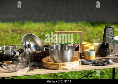 Molti articoli da cucina diversi su tavolo di legno all'aperto. Garage in vendita Foto Stock