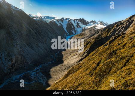 Sorvolando le alpi meridionali innevate e guardando giù le maestose vette innevate delle montagne, dei ghiacciai e dei fiumi intrecciati Foto Stock