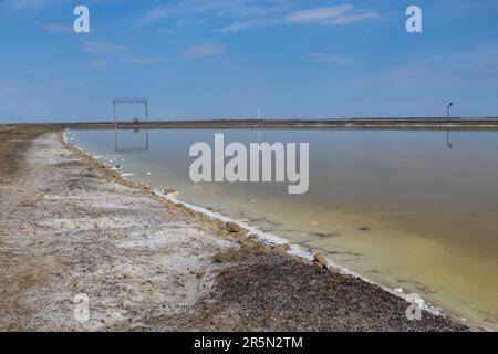 Le pietre sono ricoperte di una crosta di sale sulle rive del Salar Baskunchak. Estrazione di sale, cielo blu, spazio copia Foto Stock