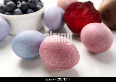 Colorate uova di Pasqua dipinte con coloranti naturali su tavola bianca, primo piano Foto Stock