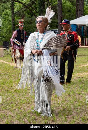 Donna nativa americana che indossa un abito con frange in pelle bianca, una borsa a conchiglia tartaruga, un ventilatore di piume e gioielli con perline che ballano in una pow wow in Evans, Geor Foto Stock
