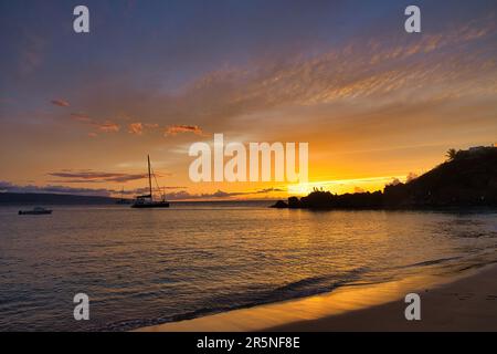 Ambiente tranquillo mentre il sole tramonta dietro Black Rock a Maui. Foto Stock