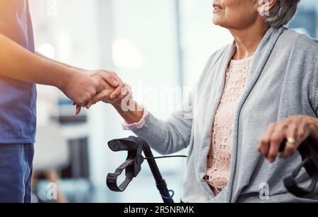 È una mano di conforto. un'infermiera femminile irriconoscibile che tiene i pazienti anziani a portata di mano. Foto Stock