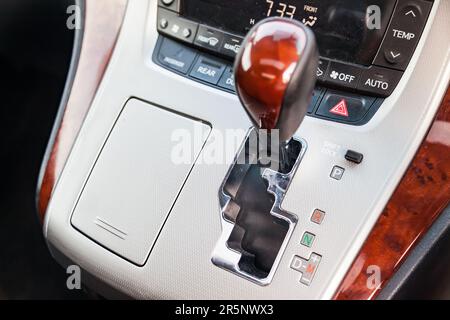 Manopola del cambio automatico nell'abitacolo della vettura nera per la guida e l'accelerazione. Immagine astratta di velocità veloce. Garanzia e re Foto Stock
