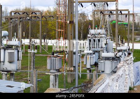 Sottostazione industriale con trasformatore industriale in ferro metallico con trasformatori e apparecchiature elettriche ad alta tensione e fili con scaricatori di sovratensione per alimentare Th Foto Stock