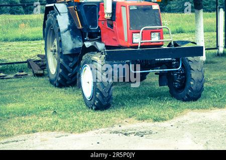 Costruzione, trasporto, trattore e ruote di grandi dimensioni di macchinari agricoli professionali con battistrada per arare campi, terreni, trasporto di g Foto Stock