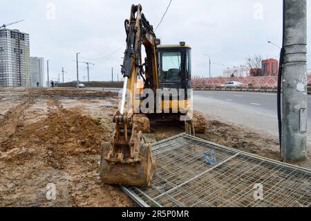 Grande giallo brillante potente escavatore industriale pesante trattore, bulldozer, attrezzature da costruzione specializzate per la riparazione stradale durante la costruzione o Foto Stock