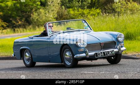 Stony Stratford, Regno Unito - Giugno 4th 2023: 1961 blu MG MIDGET auto classica in viaggio su una strada di campagna inglese. Foto Stock