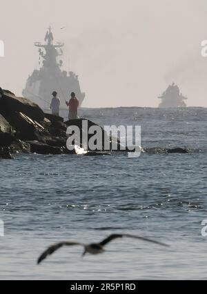 Jacksonville, Florida, Stati Uniti. 7th Nov 2015. Le persone pescano su un molo mentre il cacciatorpediniere cinese di missili guidati Jinan (a sinistra) e la fregata missilistica guidata Yiyang si dirigono verso il mare dopo la partenza dalla Stazione Navale Mayport, a Jacksonville, dopo una visita programmata di più giorni al porto. Tre navi della Marina militare dell'Esercito di Liberazione del Popolo (PIANO) sono arrivate alla base di Mayport il 2 novembre 2015 come parte di un dispiegamento in tutto il mondo dopo aver completato le chiamate portuali in Europa. (Credit Image: © Paul Hennessy/SOPA Images via ZUMA Press Wire) SOLO PER USO EDITORIALE! Non per USO commerciale! Foto Stock