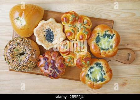 Succulenti panini dolci e salati assortiti su tavola di legno Foto Stock