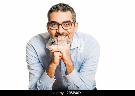 Studio ritratto di bell'uomo che indossa camicia e occhiali blu, appoggiandosi sulle mani, posando su sfondo bianco Foto Stock