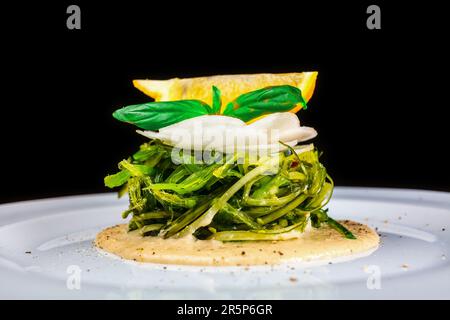Un piatto colorato di basilico fresco e mozzarella di verdure con salsa al limone, perfetto per una cucina sana all'interno. Foto Stock