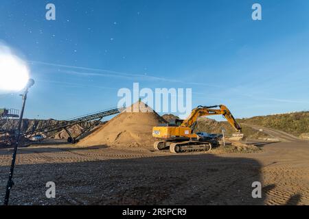 Escavatore che lavora su un'area di sabbia in un cantiere. Foto Stock