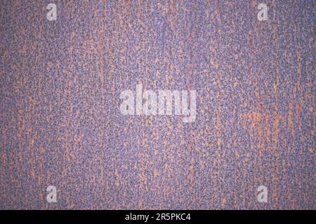 Modello astratto di struttura in metallo arrugginito. Sfondo in ferro marrone arancione viola. Parete in metallo arrugginita dipinta di viola all'aperto Foto Stock