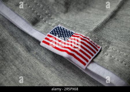 Bandiera americana ricamata su tessuto grigio. Bandiera USA su sfondo grigio. Ricamo americano. Foto Stock