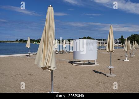 Zaton, Croazia - 18 maggio 2023 - la spiaggia di mare con ombrelloni a Zaton la mattina di una giornata di sole primaverile Foto Stock