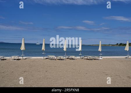 Zaton, Croazia - 18 maggio 2023 - la spiaggia di mare con ombrelloni a Zaton la mattina di una giornata di sole primaverile Foto Stock