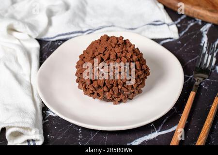 Torta al cioccolato. Torta di mole con gocce di cioccolato su sfondo scuro Foto Stock