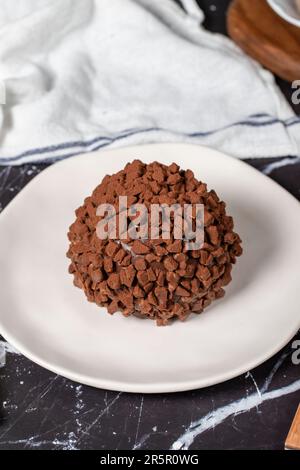 Torta al cioccolato. Torta di mole con gocce di cioccolato su sfondo scuro Foto Stock