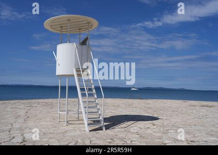 Zaton, Croazia - 18 maggio 2023 - la spiaggia di mare e il bagnino si trovano a Zaton la mattina di una giornata di sole primaverile Foto Stock