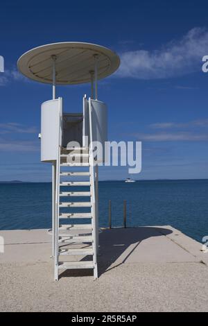 Zaton, Croazia - 18 maggio 2023 - la spiaggia di mare e il bagnino si trovano a Zaton la mattina di una giornata di sole primaverile Foto Stock