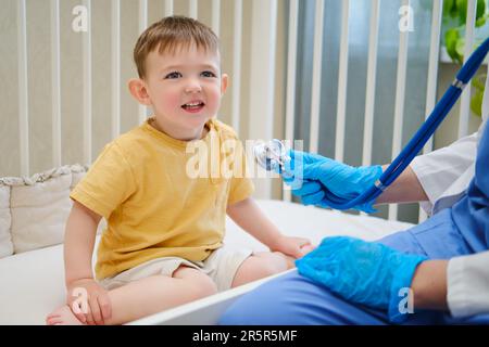 Il medico ha utilizzato uno stetoscopio per ascoltare il battito cardiaco del bambino del paziente. Bambino di circa due anni (un anno undici mesi) Foto Stock