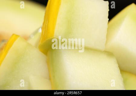 Un primo piano di un assortimento di frutta affettata di fresco con il resto della frutta visibile sullo sfondo Foto Stock